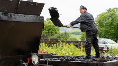 Gleisbauchef und Lokführer Dietmar Fischer bekohlt Lok 12 am Morgen vor der Premierenfahrt